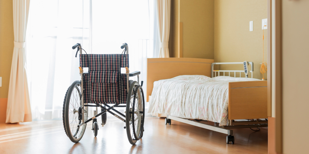 hospital room with bed and wheelchair