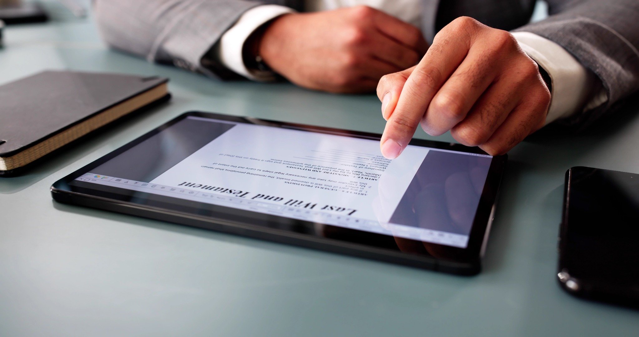 man in suit looking at document on tablet
