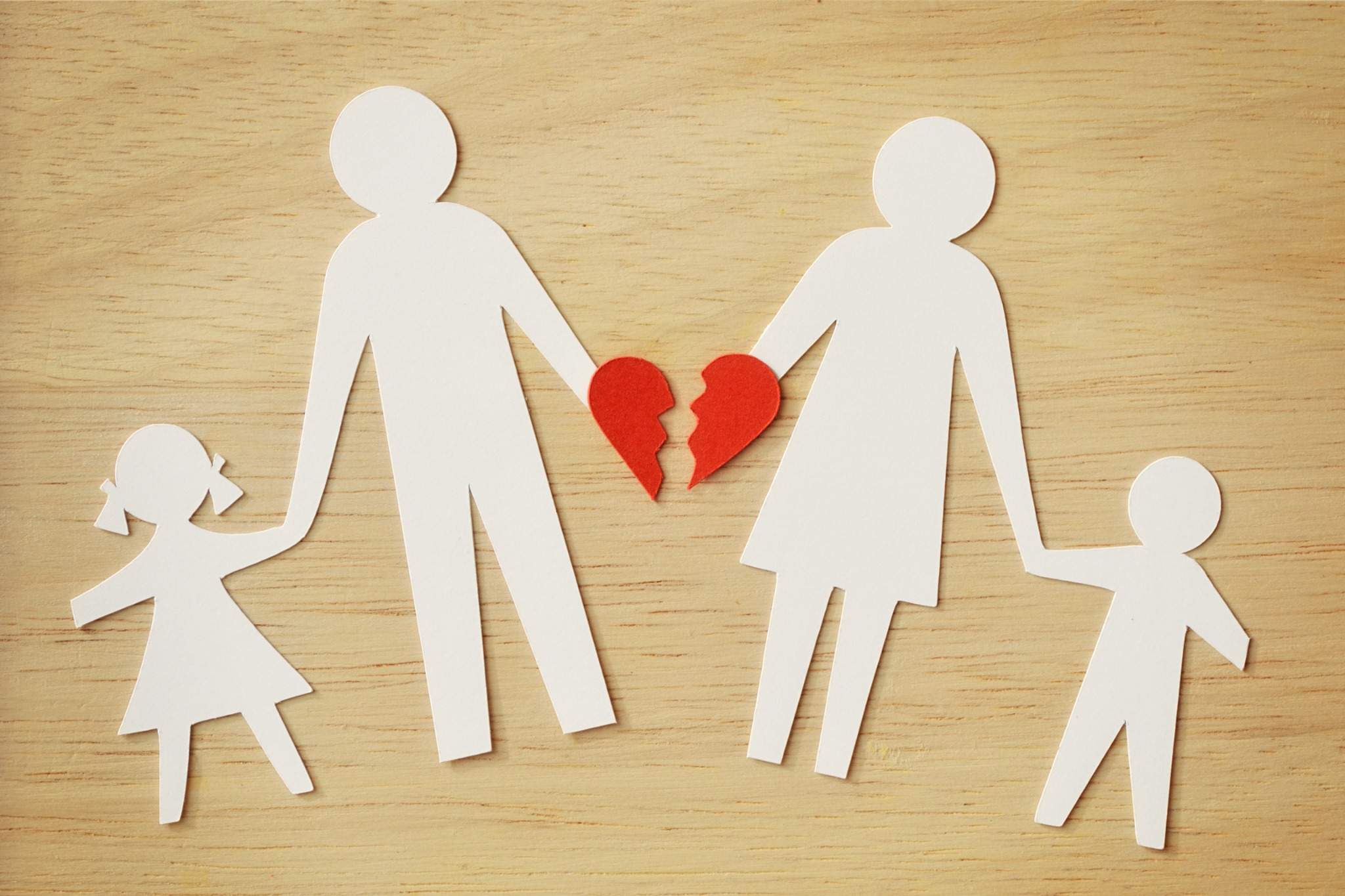 paper cutout of a family with a broken heart at the center